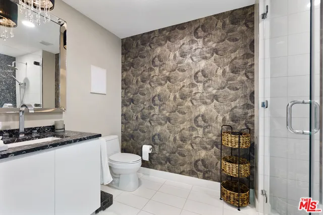 a bathroom with a granite countertop sink a toilet and a shower