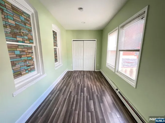 a view of a room with wooden floor and windows