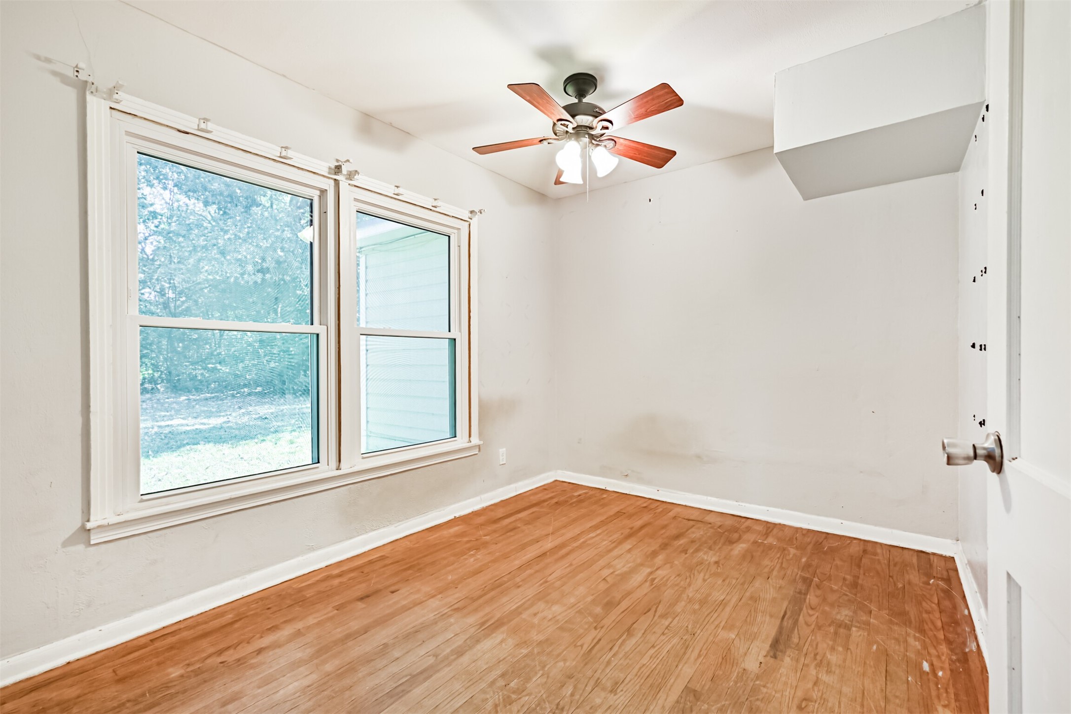 1007 Plum Street La Marque, TX 77568 - Photo 11 of 16 wooden floor in an empty room with a window