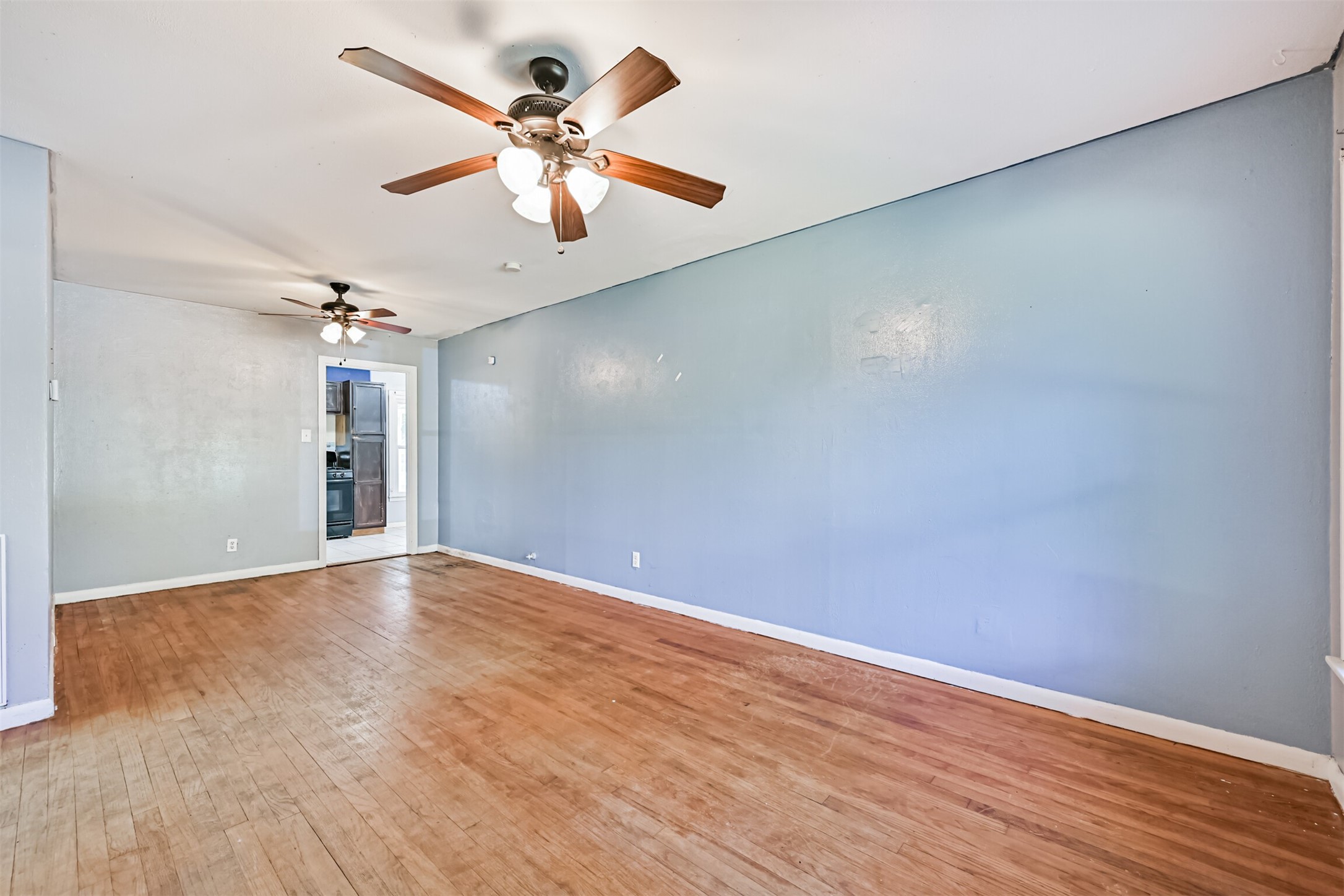 1007 Plum Street La Marque, TX 77568 - Photo 3 of 16 wooden floor in an empty room with a window