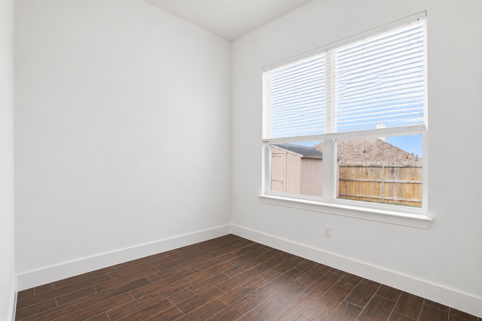 133 Greg Lane Jarrell, TX 76537 - Photo 17 of 24 Room featuring wood-finish tile flooring, white baseboards, a large window with blinds, and white walls