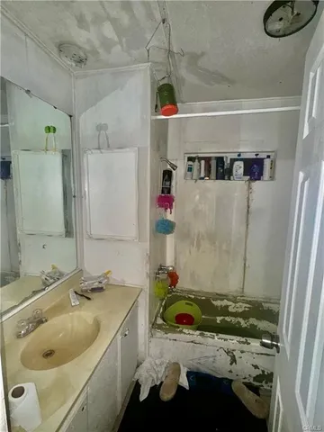 a bathroom with a granite countertop sink and a shower
