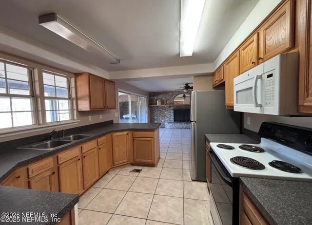 a kitchen with stainless steel appliances granite countertop a refrigerator a stove a sink and a microwave