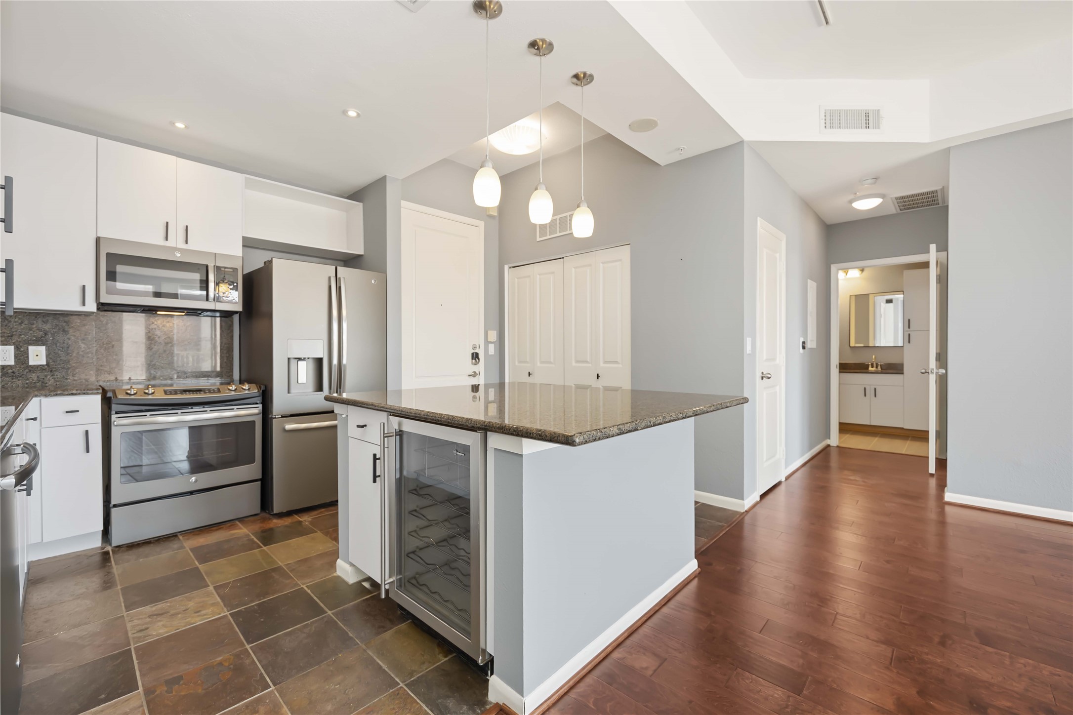 3505 Sage Road, Unit 1508 Houston, TX 77056 - Photo 4 of 23 This alternative kitchen view highlights the adjacent utility space with washer/dryer connections and open sightlines to the living area, creating an efficient and connected workspace for cooking.