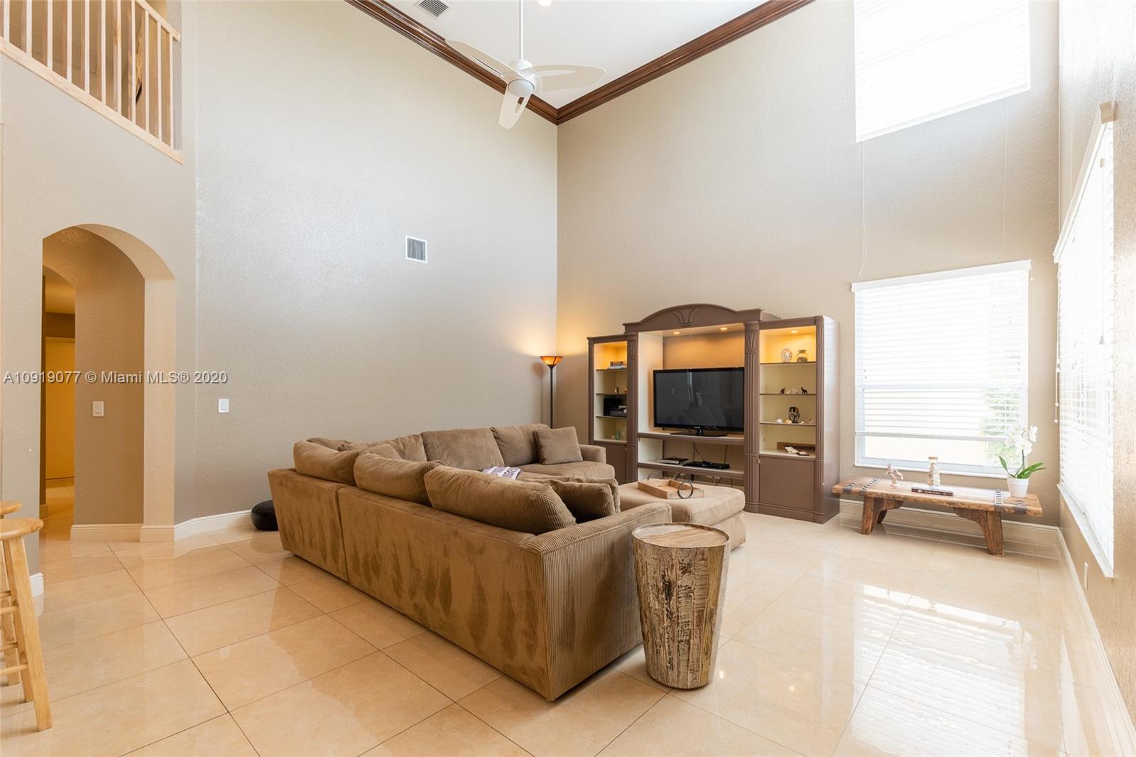 12358 St Simon Drive Boca Raton, FL 33428 - Photo 25 of 89 a living room with a couch and a flat screen tv