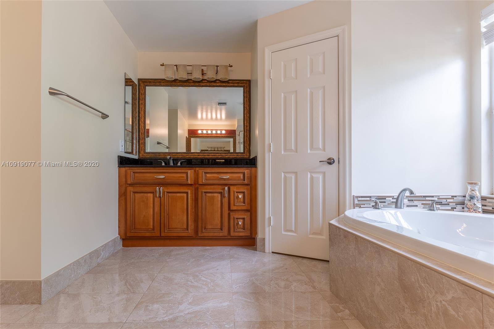 12358 St Simon Drive Boca Raton, FL 33428 - Photo 40 of 89 a spacious bathroom with a sink a mirror and a bathtub