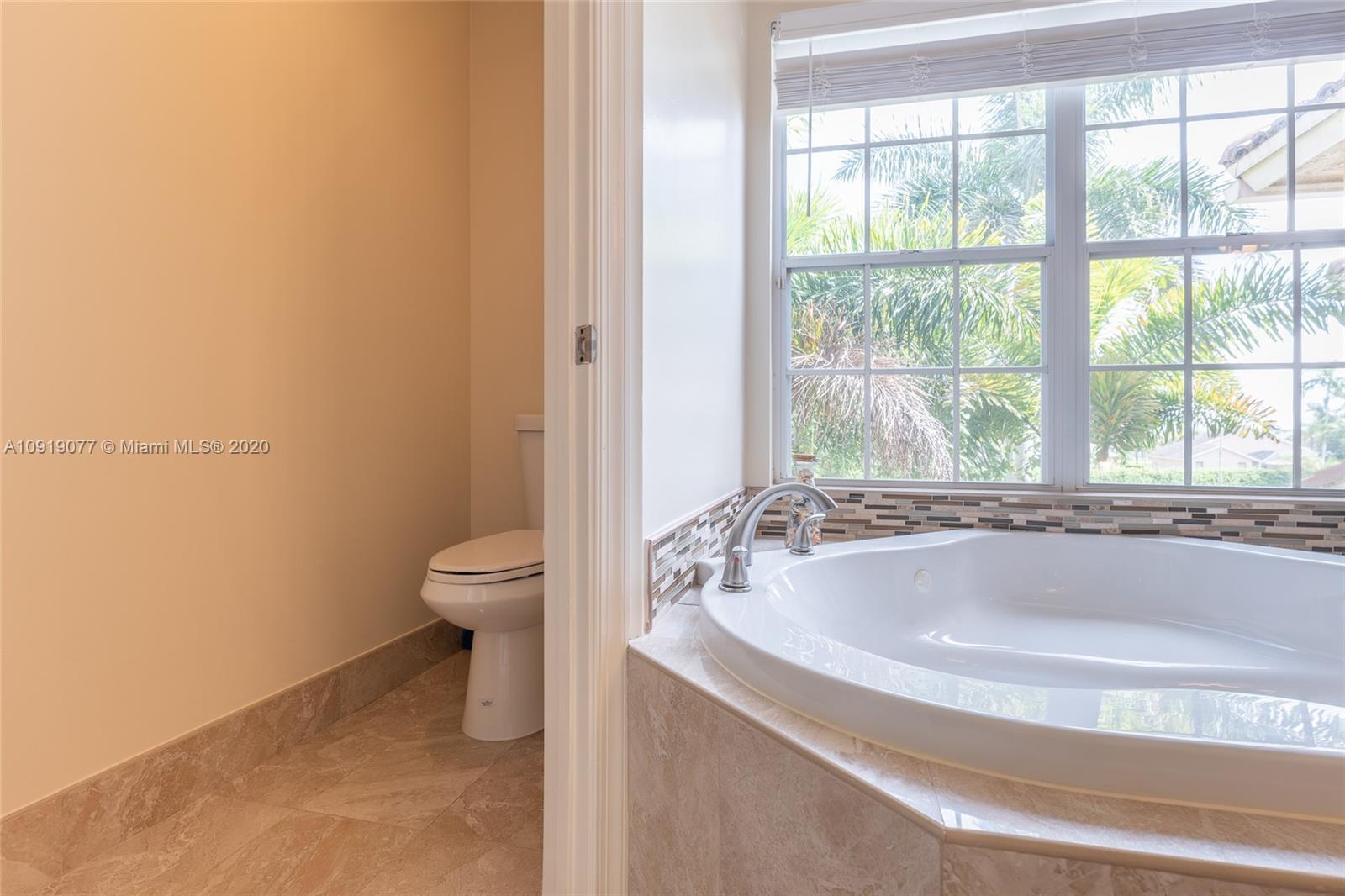 12358 St Simon Drive Boca Raton, FL 33428 - Photo 41 of 89 a spacious bathroom with a granite countertop tub a toilet and a sink