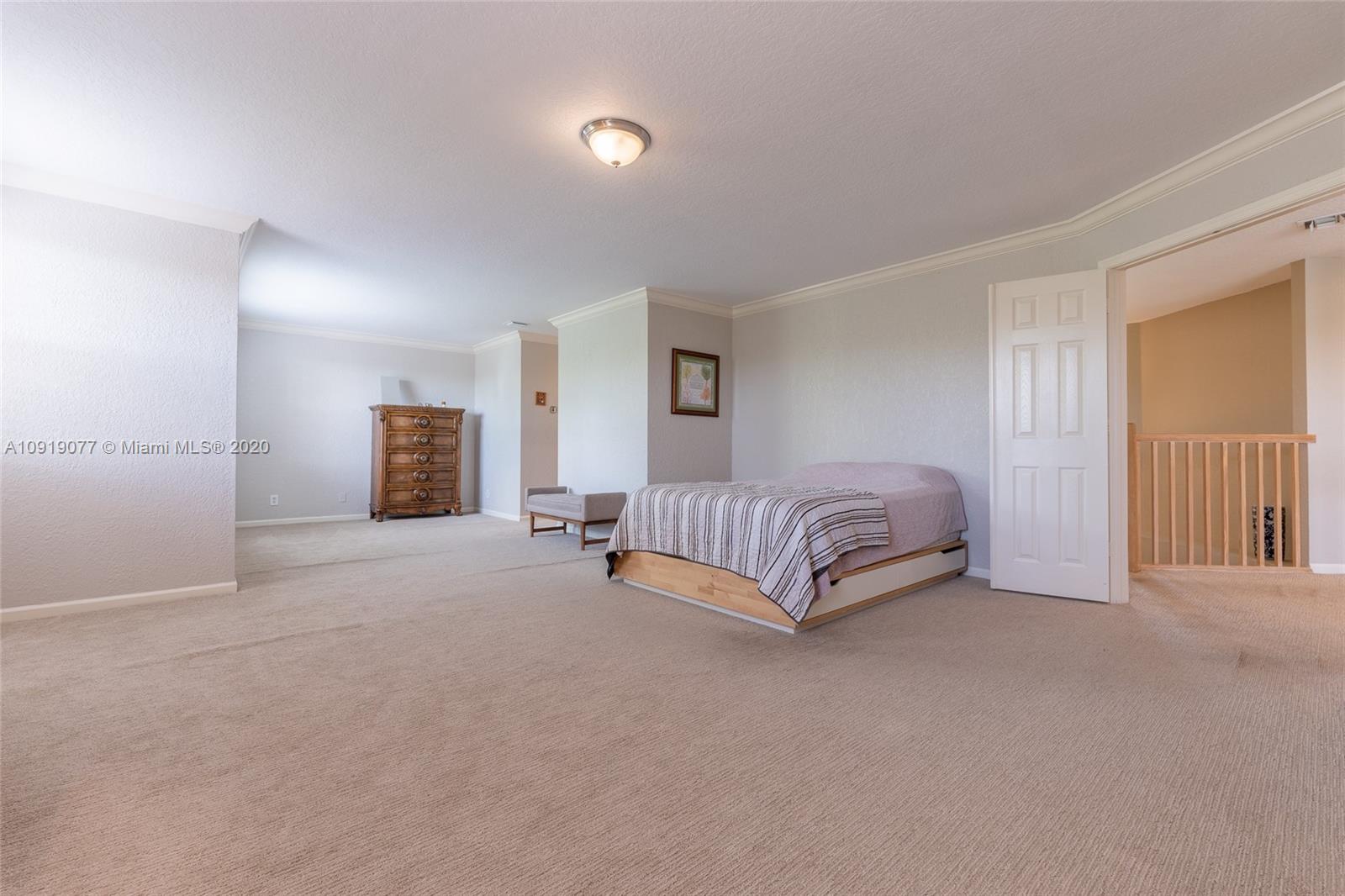 12358 St Simon Drive Boca Raton, FL 33428 - Photo 48 of 89 a spacious bedroom with a bed and a lamp