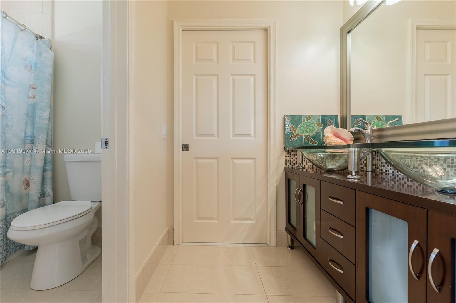 12358 St Simon Drive Boca Raton, FL 33428 - Photo 51 of 89 a bathroom with a granite countertop sink a toilet and a mirror