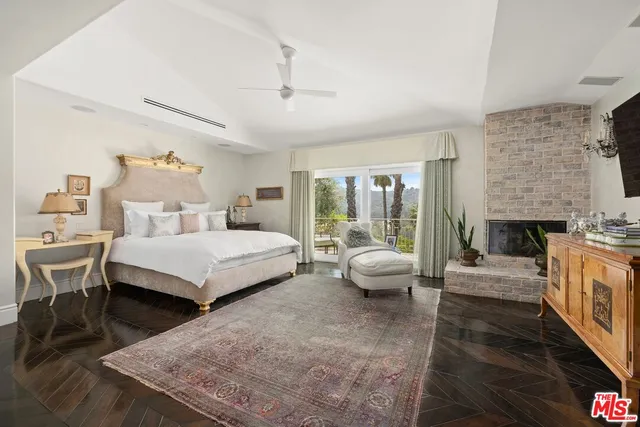 a bedroom with a bed couch and a fireplace