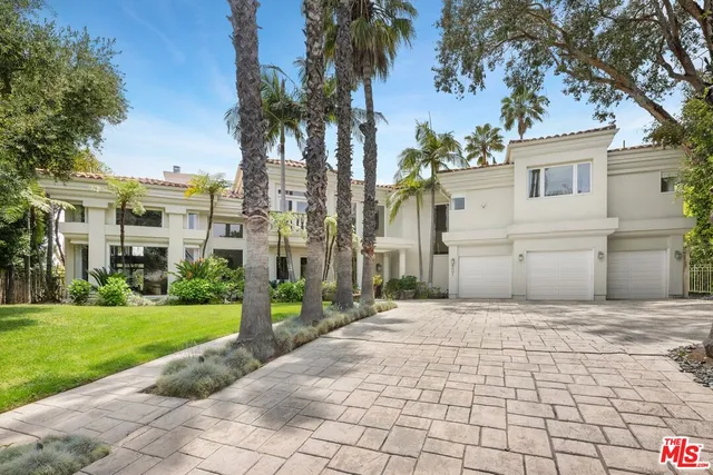 a view of a white house with a yard and potted plants