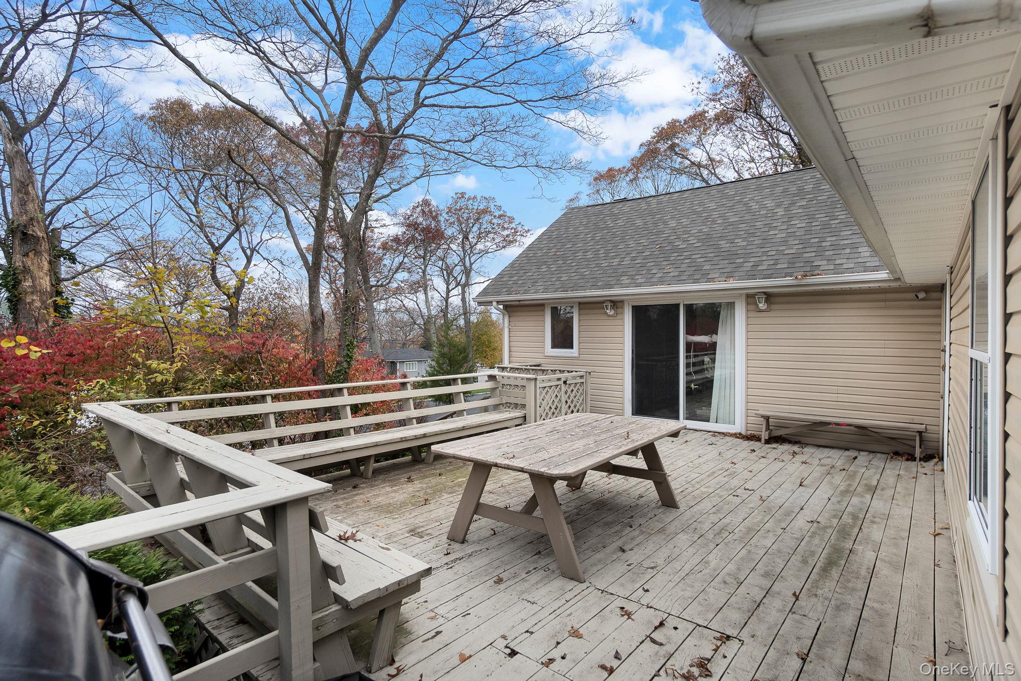 8 Evergreen Road Rocky Point, NY 11778 - Photo 19 of 20 a view of a roof deck with table and chairs and wooden floor