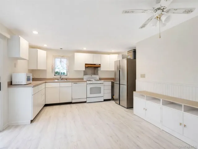 a kitchen with white cabinets and white appliances