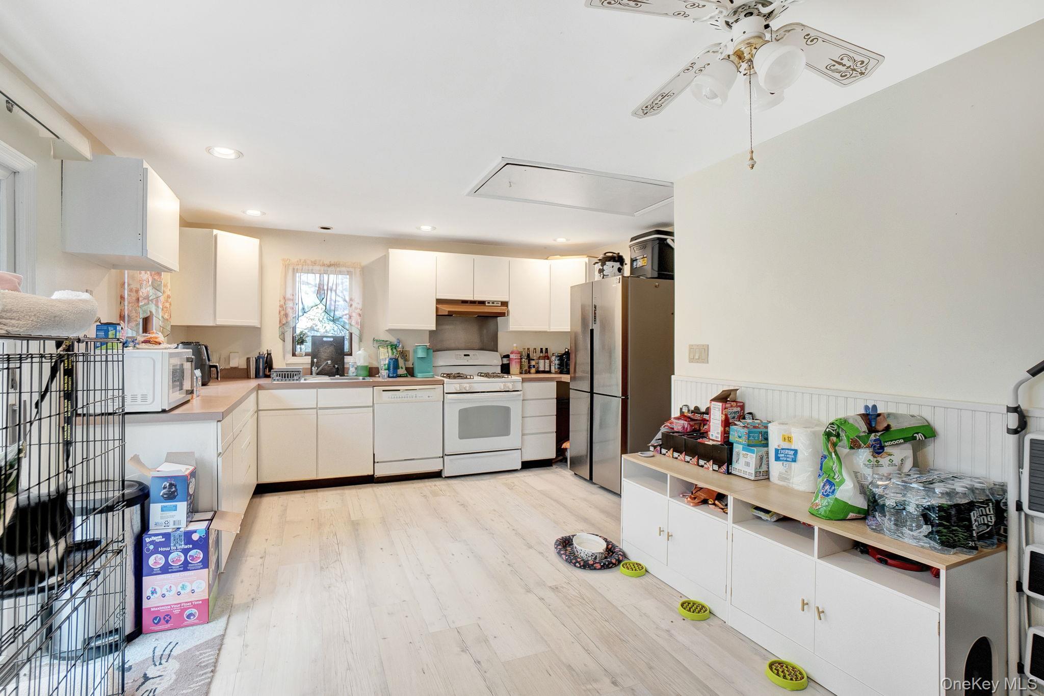 8 Evergreen Road Rocky Point, NY 11778 - Photo 5 of 20 a kitchen that has a lot of white cabinets and stainless steel appliances