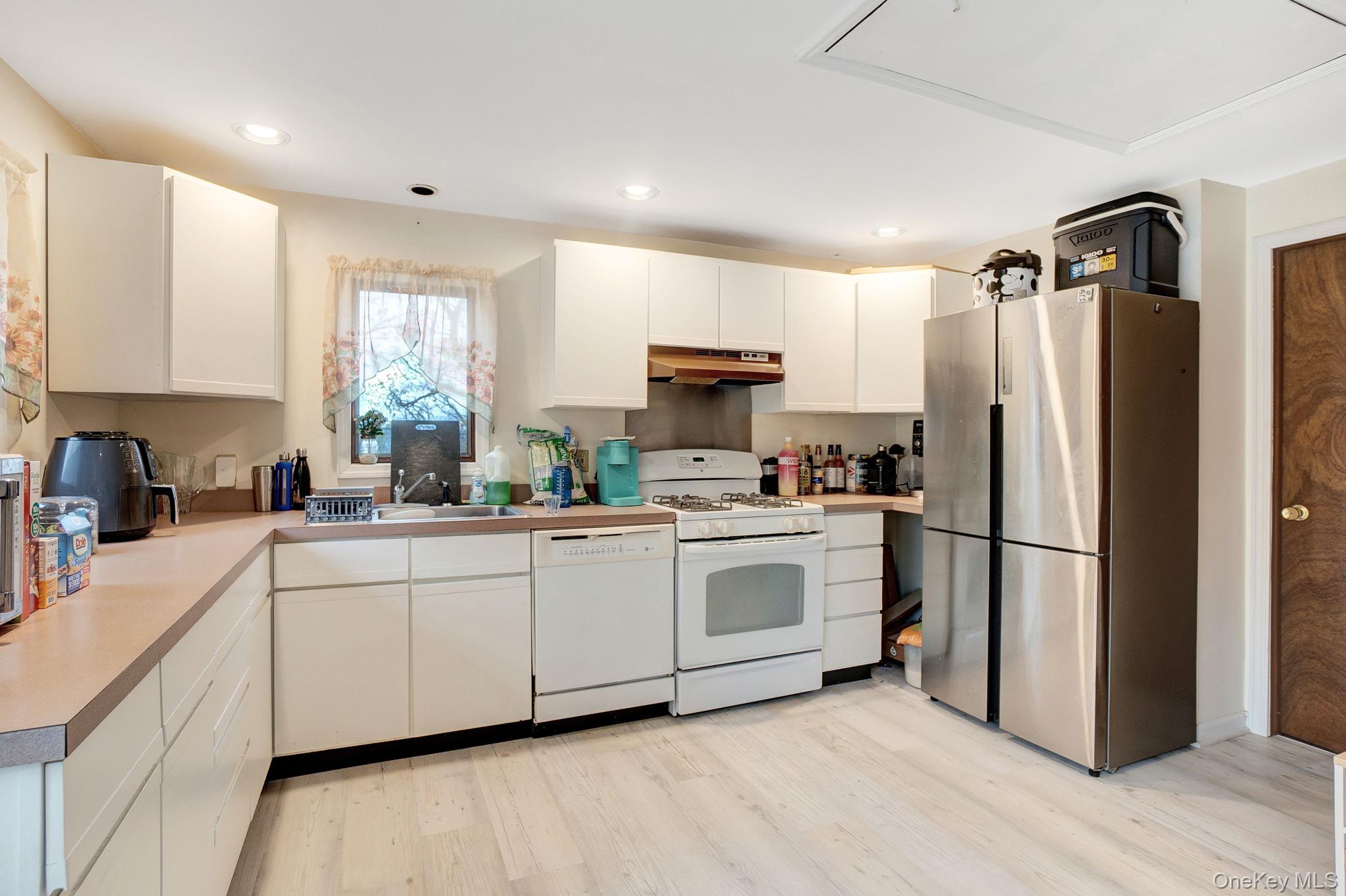 8 Evergreen Road Rocky Point, NY 11778 - Photo 7 of 20 a kitchen with white cabinets white stainless steel appliances and a window
