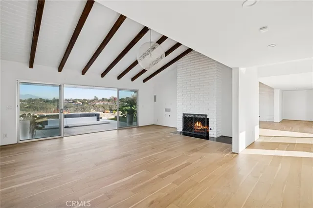 an empty room with wooden floor and fireplace