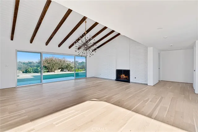 a view of empty room with wooden floor and fireplace