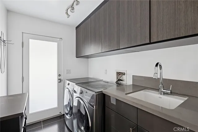 a utility room with sink dryer and washer