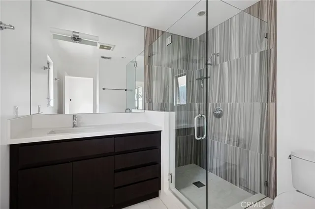 a bathroom with a shower sink vanity and mirror