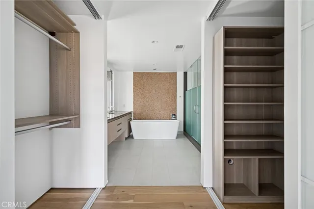a bathroom with a tub a sink and mirror