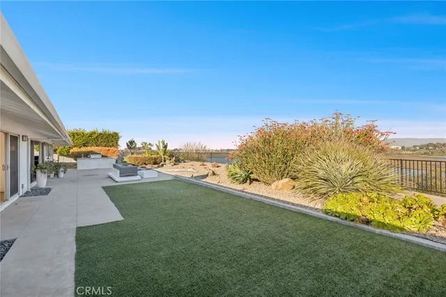 a front view of house with yard and trees in the background