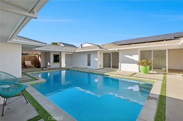 a view of a house with swimming pool and sitting area