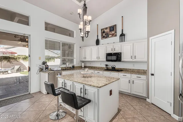 a kitchen with kitchen island granite countertop a sink cabinets and stainless steel appliances
