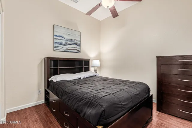 a bedroom with a bed and a painting on the wall