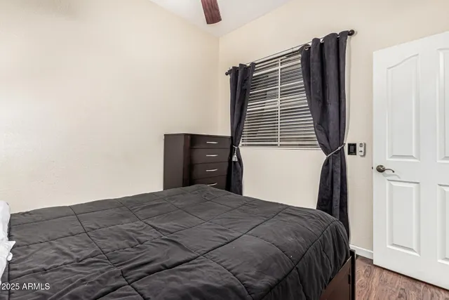 a bedroom with a bed and a flat tv screen on the dresser