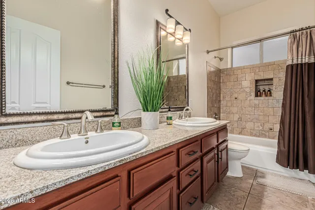 a bathroom with a double vanity sink toilet and shower