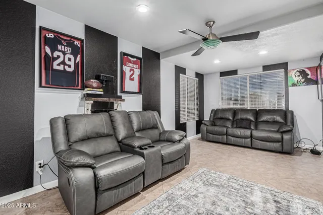 a living room with furniture ceiling fan and a rug
