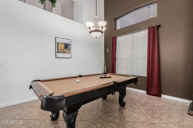a room with pool table and windows