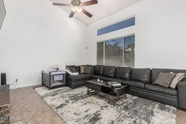 a living room with furniture ceiling fan and a window