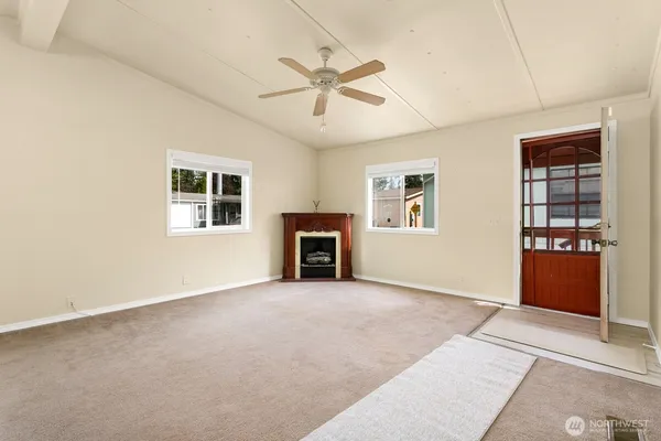 an empty room with windows and ceiling fan