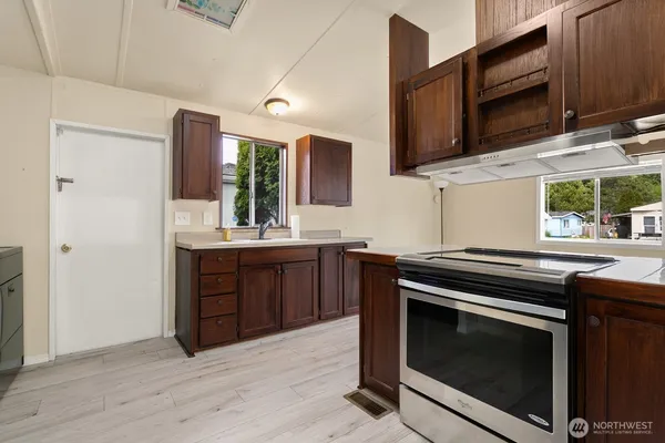 a kitchen with stainless steel appliances a stove microwave and sink