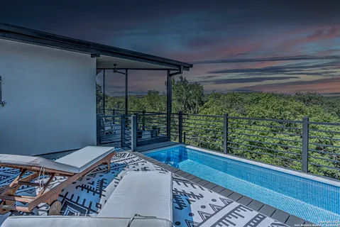 a bed sitting in a balcony next to a window