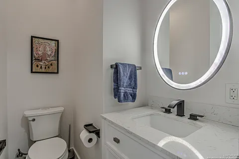 a bathroom with a toilet a sink and mirror