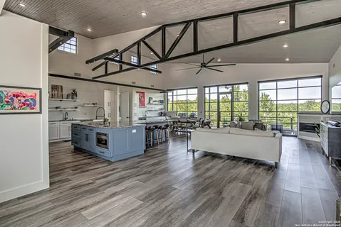 a large room with lots of wooden furniture and stainless steel appliances