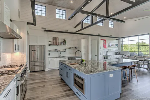 a kitchen with stainless steel appliances granite countertop a wooden cabinets and a stove