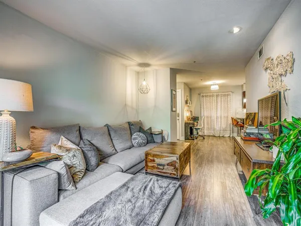 a living room with furniture and a wooden floor