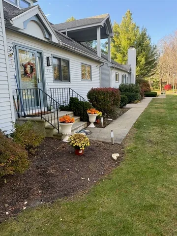 a view of a house with backyard and sitting area