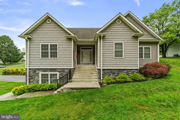 a front view of a house with a yard and green space