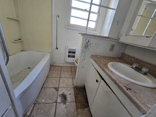 a bathroom with a granite countertop sink a toilet and bathtub