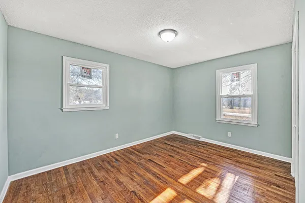a view of a room with wooden floor and window