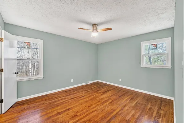 a view of empty room with wooden floor