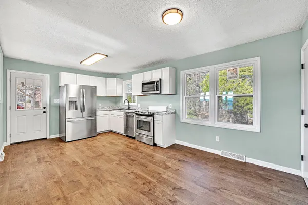 a kitchen with stainless steel appliances a refrigerator sink and cabinets