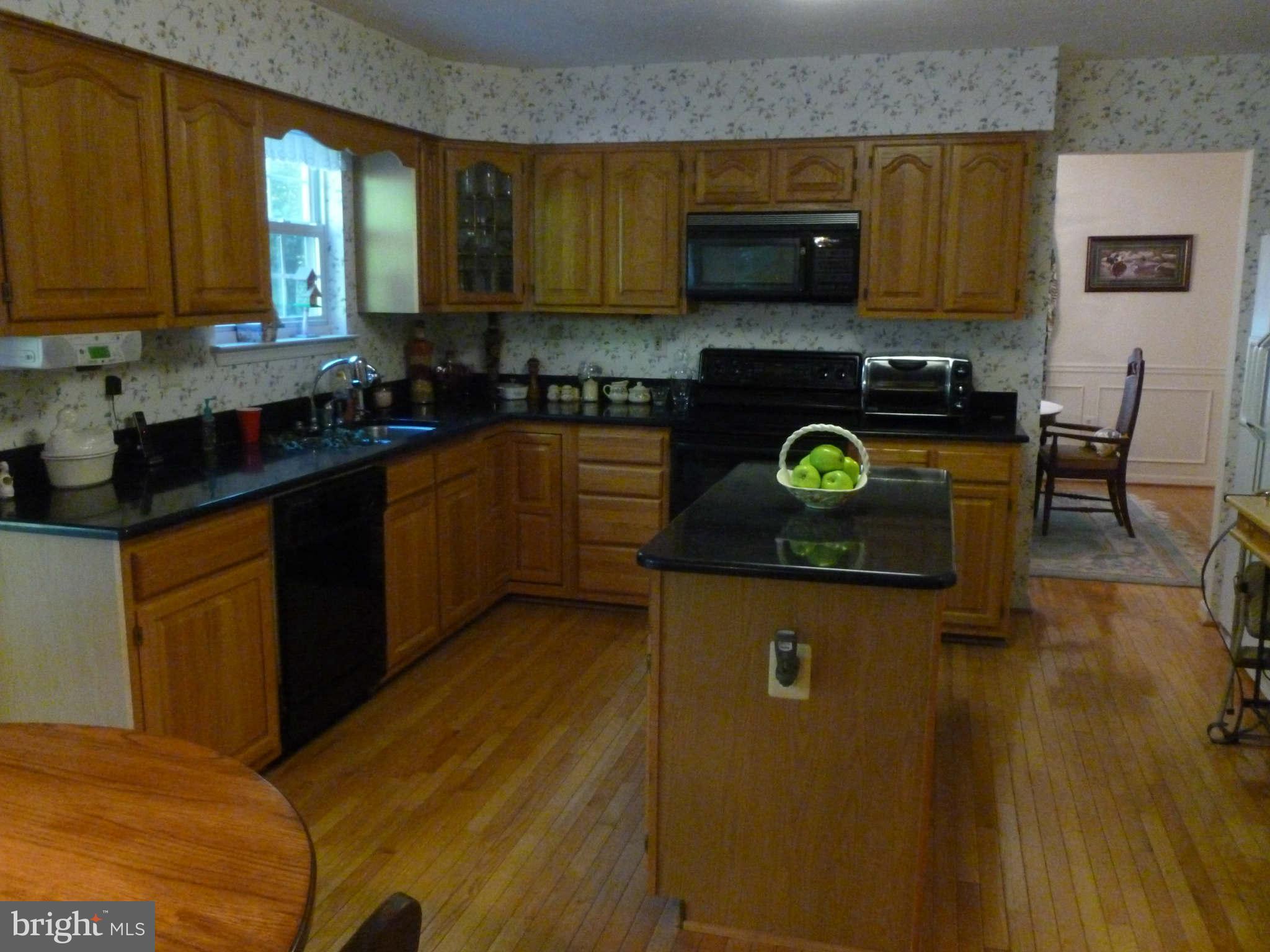 670 Small Reward Road Huntingtown, MD 20639 - Photo 8 of 26 a kitchen with stainless steel appliances granite countertop a stove a sink and a microwave