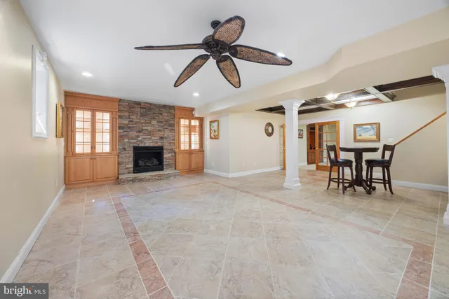 an empty room with wooden floor and ceiling fan