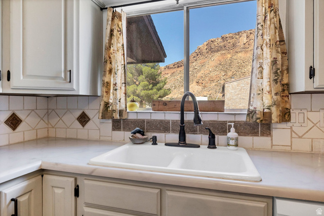 3334 Ute Road St. George, UT 84790 - Photo 10 of 40 Kitchen featuring light countertops, decorative backsplash, white cabinets, and a mountain view