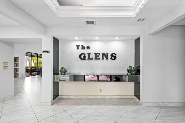 a large white kitchen with a window and refrigerator